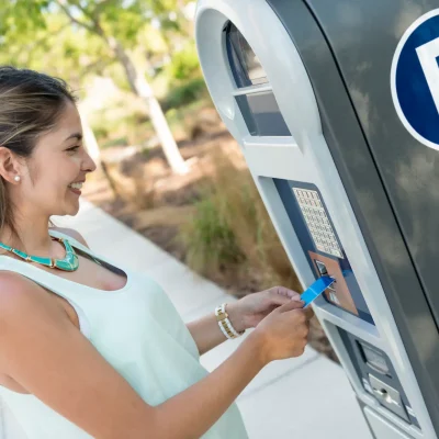 Woman using a Level 2 parking meter to pay for her parking spot.