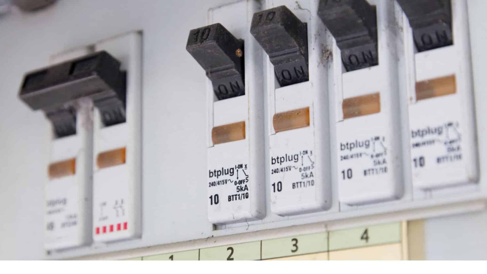 Electrical circuit breakers in the "on" position on a panel for charging electric vehicles.