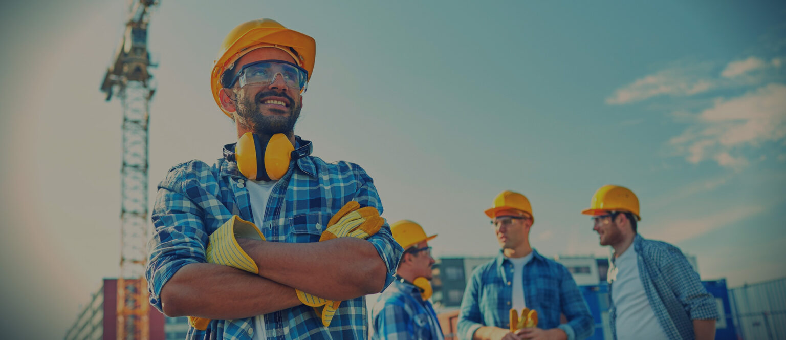 Construction workers in safety gear on a job site installing Arizona commercial EV charging stations.
