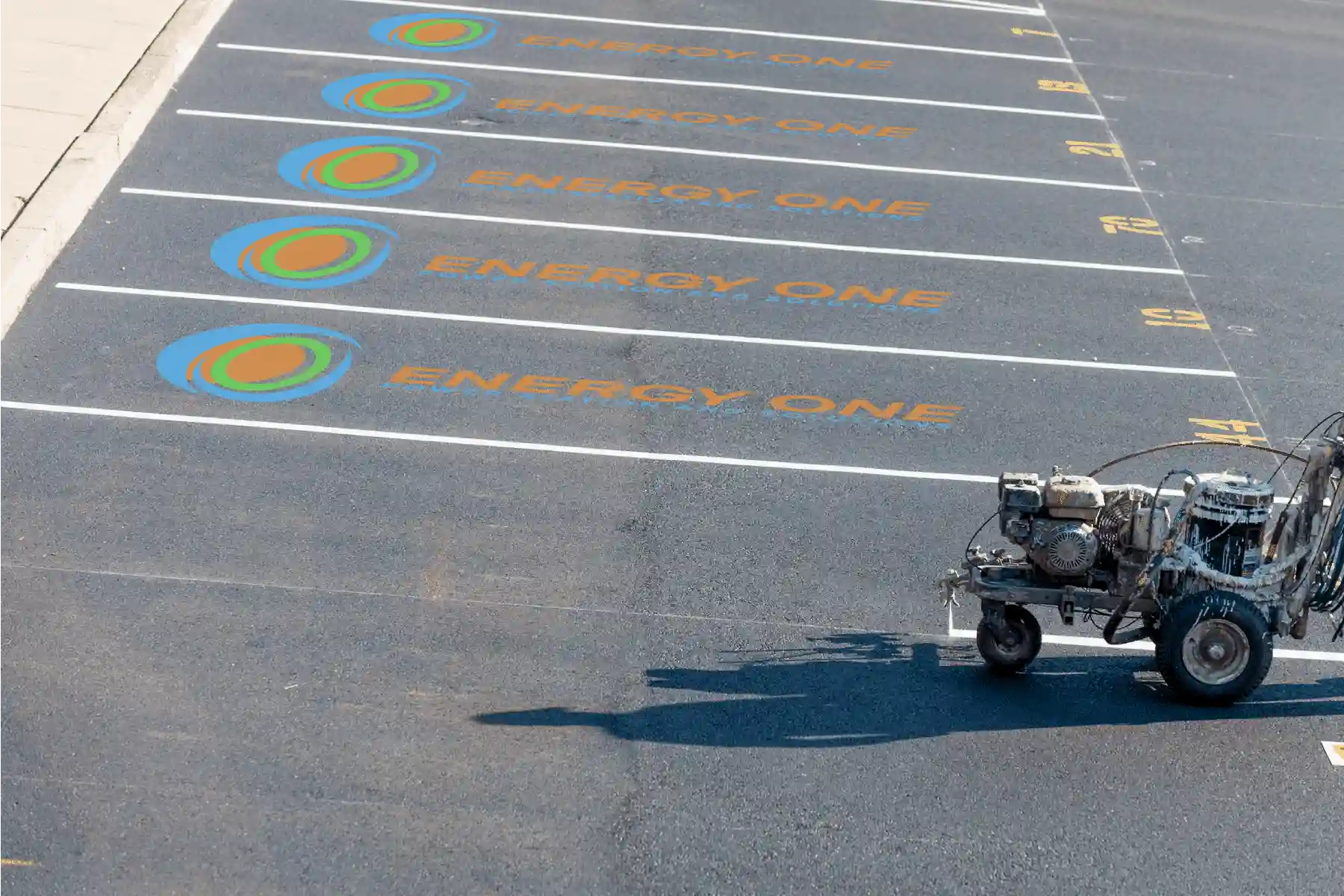 Designated electric vehicle charging spots marked on an asphalt parking lot.